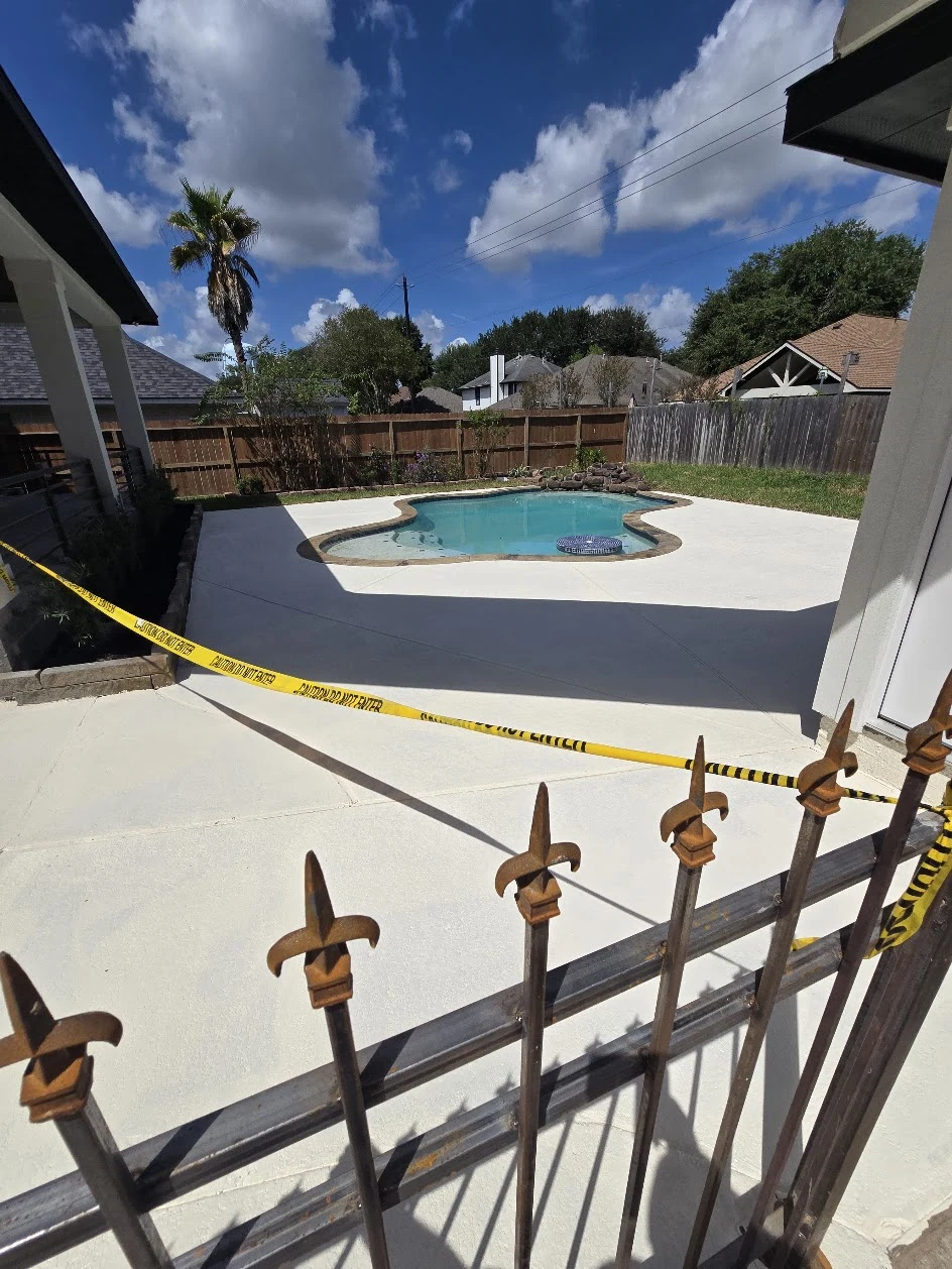 United Concrete patio surrounding a backyard pool