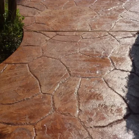 Warm brown stamped concrete with textured stone pattern